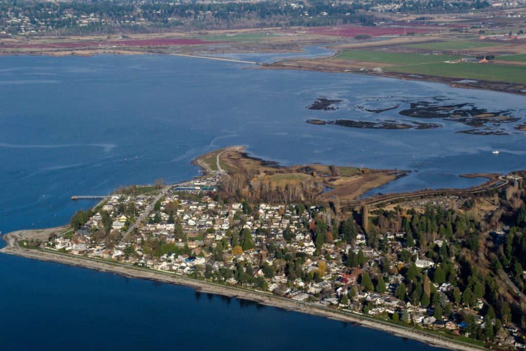 Aerial photograph of the coastal area of Surrey, British Colombia. The area in the photo is a densely populated low-lying suburb on the coastline.